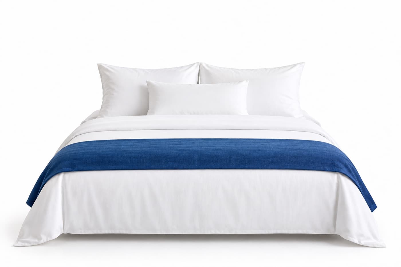 A hotel bed made up in white linen with a blue runner across the foot